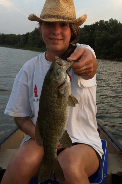 amy_342135132.PNG - Amy on the Guelph Lake holding a smallmouth bass caught with a White spinner bait.
